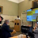 Photo of session at the UKFIET conference with a presenter and slides for a case study in Ghana