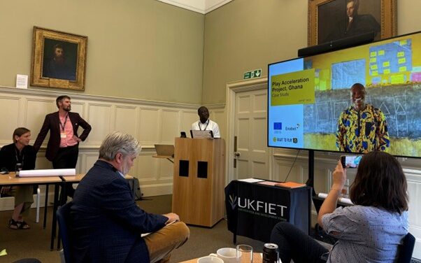 Photo of session at the UKFIET conference with a presenter and slides for a case study in Ghana