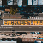 Road from above with ‘END RACISM NOW’ painted on it, Philadelphia, USA.