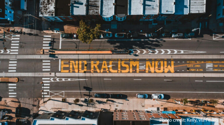 Road from above with ‘END RACISM NOW’ painted on it, Philadelphia, USA.