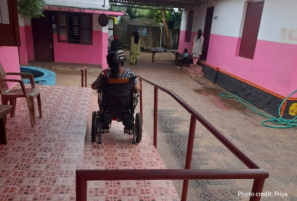 Priya, a female teacher with a physical disability from a government primary school in Kerala, India, descends a ramp in a wheelchair.