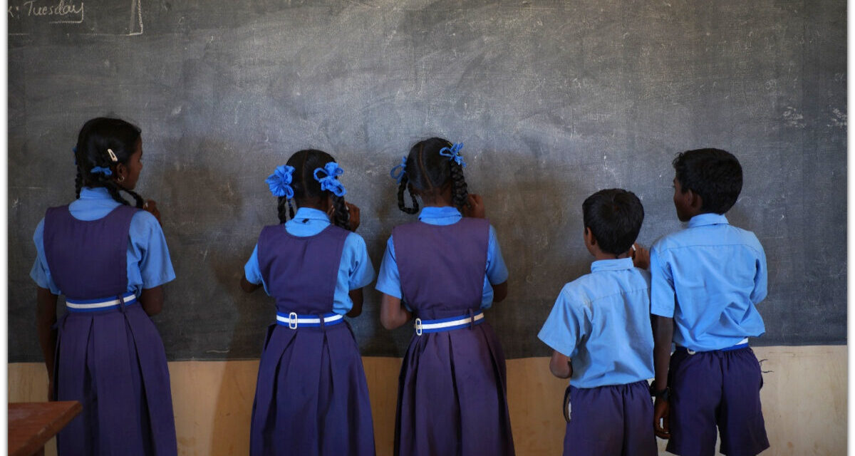 unlearning gender Five girls and boys stand facing the blackboard in a classroom, India.