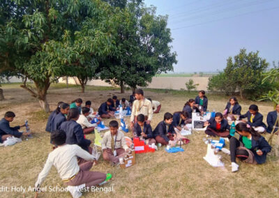 Children sit outside doing an interactive class.