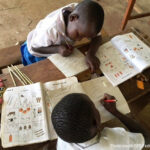 Two students do maths work together in class, Nairobi, Kenya.