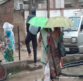 People walking with umbrellas and other rain protection