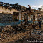 A fire damaged school being repaired. Two notices : Education is our future. And Our School Will rise again, Let us keep every child in school