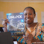 A GEL facilitator at a learning centre at Kakuma Refugee Camp in Kenya holding a Cambridge coursebook