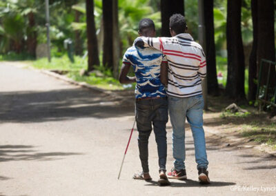 Two men walking together - Peer support from a fellow student for a visually impaired student, Oromia, Ethiopia