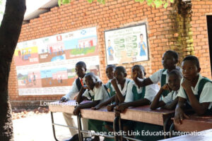 Children sit at their desks outside, during Disaster Risk Management Club, Malawi.