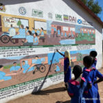 Children look at a school mural, Malawi