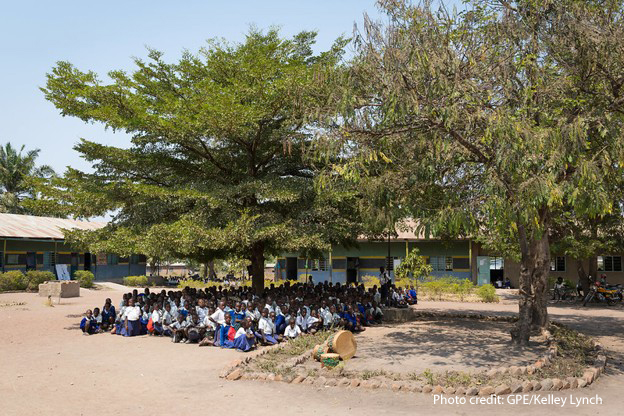 Turning Committments Primary school students wait for their class to start in the shade of a tree, Tanzania.
