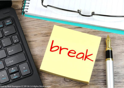 Post it note with "break" written on it in red. with keyboard and pen alongside