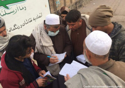 An adult literacy facilitator providing homework for adult learners on the pavement