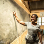 A female teacher, Risper, who specialises in the educational needs of disabled children, stands at the blackboard, Kenya.