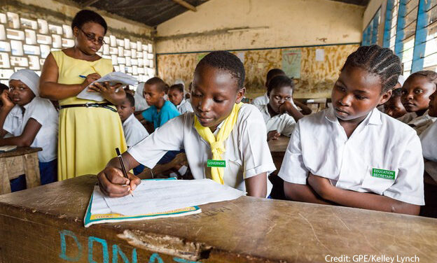 A female teacher stands in her classroom while the students do an exercise, Kenya.