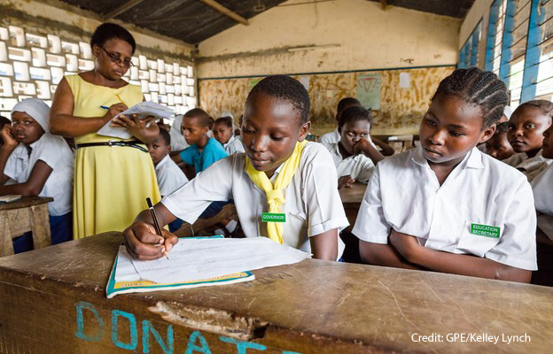 Trained Teachers A female teacher stands in her classroom while the students do an exercise, Kenya.
